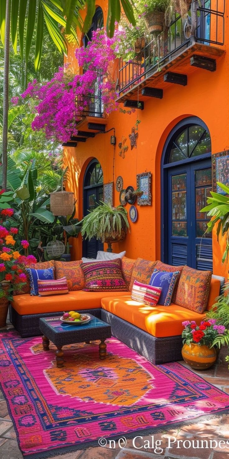 an orange couch sitting on top of a colorful rug in front of a yellow building