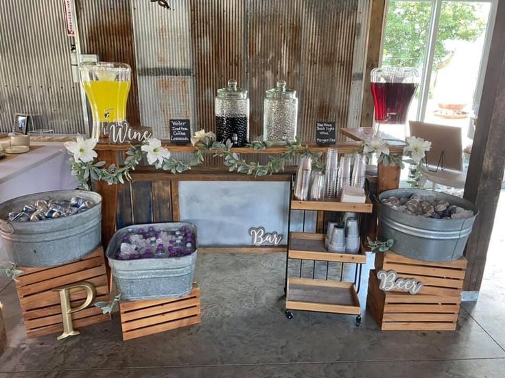 several buckets are stacked on top of each other in front of a table with drinks