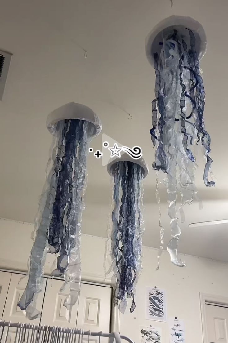 three jellyfish hanging from the ceiling in a room