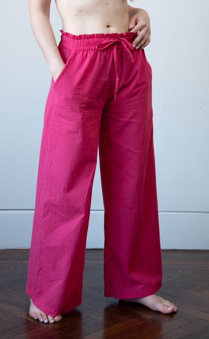 Our wide leg cotton voile pajama pants are so comfortable you'll forget that you're wearing them. Designed with an easy fit elasticized waist and a full leg for maximum comfort. The soft cotton is perfect for sleeping in or just lounging around. Wear them with a simple cotton t-shirt or the matching top (sold separately) and you will be be the best dressed person in your dreams. ♦︎ Fabric: 100% Cotton Voile ♦︎ Softly elasticzied drawstring paperbag waist ♦︎ Two front slash pockets ♦︎ Please note Pink Wide Leg Pants With Elastic Waistband For Loungewear, Pink Cotton Wide Leg Pants With Elastic Waistband, Vacation Cotton Parachute Pants With Relaxed Fit, Cotton Pants For Summer Pajama Party, Relaxed Fit Cotton Parachute Pants For Vacation, Vacation Relaxed Fit Cotton Parachute Pants, Cotton Parachute Pants For Spring Vacation, Comfortable Cotton Wide Leg Pants With Elastic Waistband, Spring Cotton Parachute Pants For Vacation