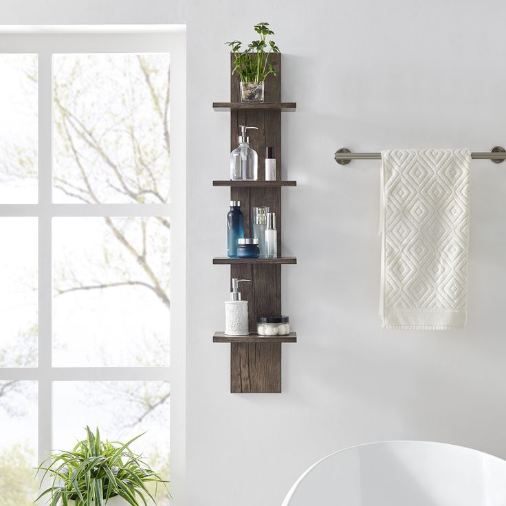 a bathroom with a white tub and wooden shelves on the wall next to a potted plant