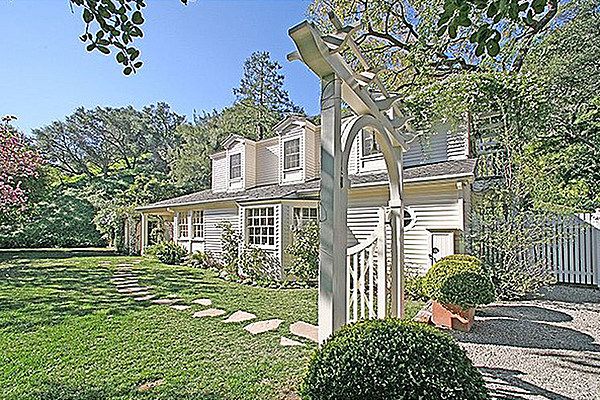 this is an image of a house in the suburbs with trees and bushes around it