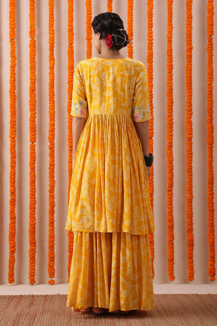 Yellow flared kurta with block floral printed motifs and embroidered neckline. Comes with gharara and dupatta.
Component: 3
Pattern: Print and Embroidery
Type Of Work: Block Print, Pearl, Thread and Sequin
Neckline: V neck
Sleeve Type: Half
Fabric: Cotton Slub and Organza
Color: Yellow
Other Details: 
Dupatta with scalloped border
Occasion: Puja - Aza Fashions Navratri Maxi Sets With Gota Work, Maxi Length Sets With Gota Work For Navratri, Navratri Gota Work Maxi Length Sets, Chanderi Sharara For Transitional Season, Festival Sharara With Chikankari Embroidery, Festival Chikankari Embroidery Maxi Length Sharara, Festival Maxi Length Sharara With Chikankari Embroidery, Festival Maxi Length Palazzo Set With Cutdana, Unstitched Maxi Length Sharara With Chikankari Embroidery