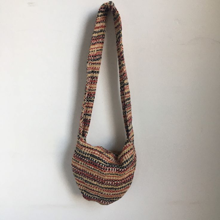 "Embrace the free-spirited vibe of the 1970s with this charming vintage shoulder bag. Crafted by hand, this one-of-a-kind purse features a beige base adorned with a vibrant woven pattern in red, black, and yellow. The thick strap ensures comfortable wear, while the fold-over closure adds a touch of practicality and style. Elevate your look with this timeless piece from the groovy era. era: 1970s measurements: approximately 10\" x 9\" x 2\" with a 15\" strap hang brand/maker: none marked conditio Vintage Beige Satchel Hobo Bag, Natural Woven Crossbody Hobo Bag, Vintage Beige Hobo Shoulder Bag, Bohemian Crochet Satchel With Braided Handles, Bohemian Brown Satchel Straw Bag, Bohemian Brown Crossbody Straw Bag, Bohemian Brown Straw Satchel Bag, Brown Bohemian Straw Bag For Everyday Use, Bohemian Straw Pouch Bag With Adjustable Strap