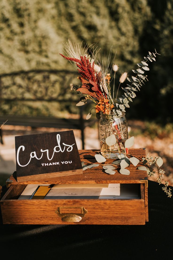 a wooden box with flowers and cards on it