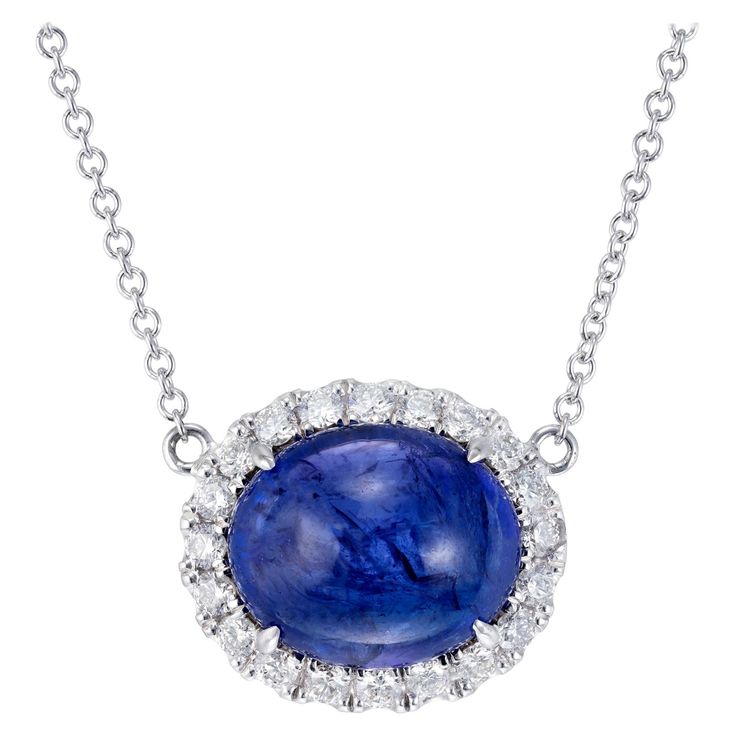 Vivid blue earth mined tanzanite and diamond pendant necklace. 8.00 carat oval cabochon center stone with blue and purple overtones surrounded a brilliant cut diamond halo. 18 inch 18k white gold chain. Created in the Peter Suchy Workshop 1 oval cabochon blue tanzanite, MI approx. 8.00cts 20 round brilliant cut diamonds, F-G VS, approx. .40cts 18k white gold Stamped: 18k 750 5.9 grams Top to bottom: 13.2mm or .5 Inch Width: 15.8mm or 5/8 Inch Depth or thickness: 9.8mm Chain: 18 Inches Total leng Round Pendant Necklace 1stdibs, Fine Jewelry Cabochon Gemstones For Formal Occasions, Formal Fine Jewelry Cabochon Gemstones, Exquisite Formal Gemstone Cabochons, Formal Fine Jewelry Gemstone Cabochons, Oval Diamond Cabochons For Formal Occasions, Formal Round Gemstone Cabochons, White Gold Gemstone Cabochons Fine Jewelry, Elegant Sapphire Cabochon Jewelry