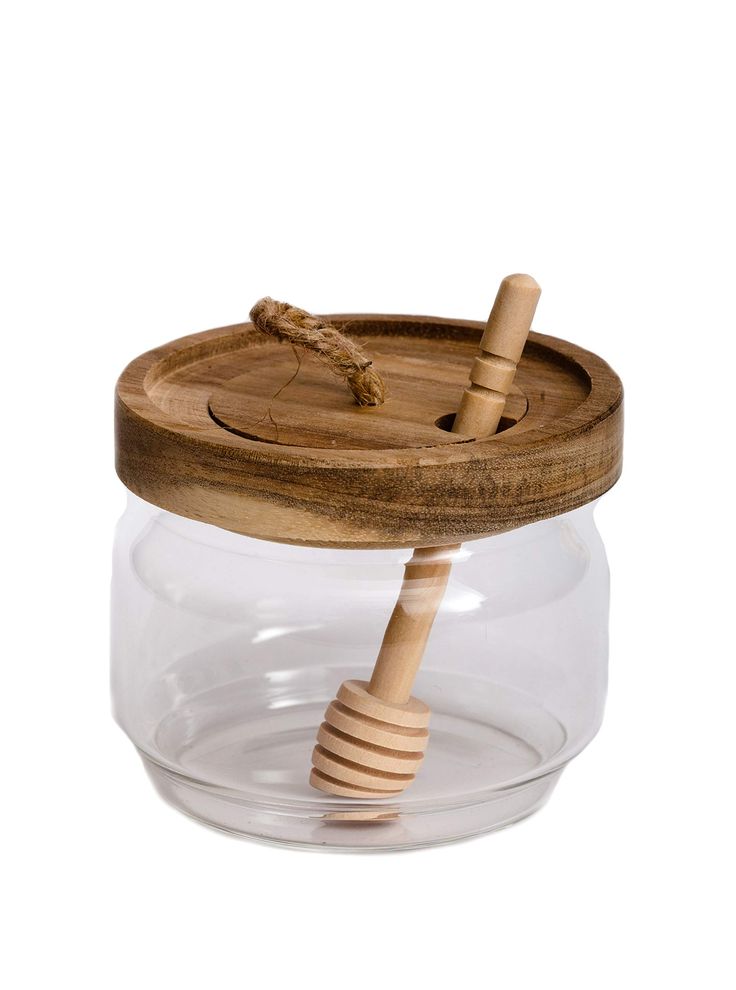 a glass jar with a wooden handle and lid