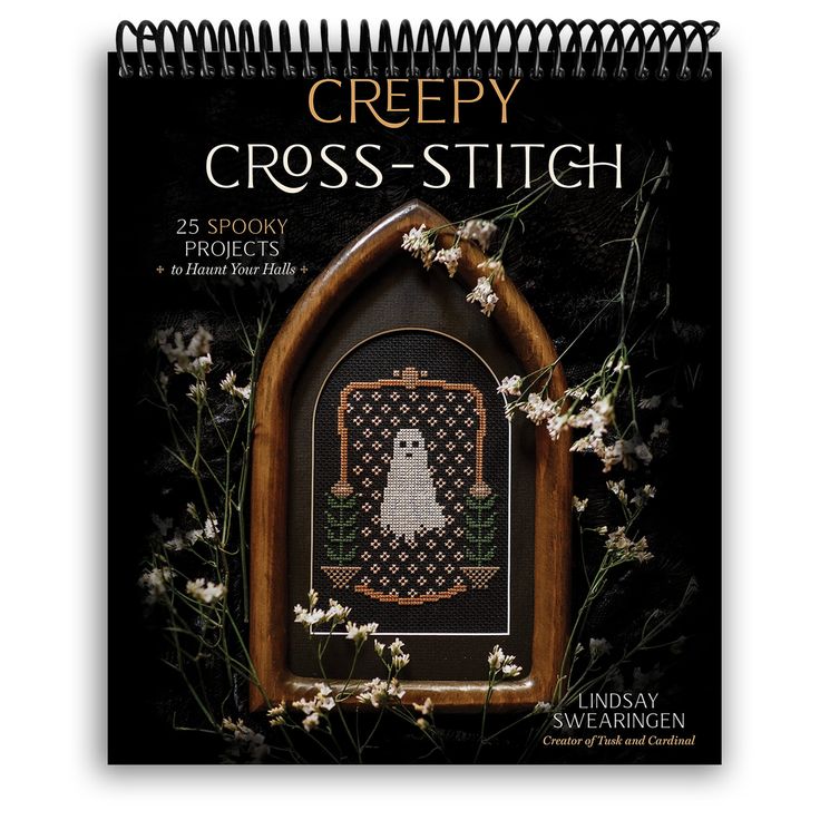 the cover of cross - stitch magazine is shown with white flowers and a wooden frame