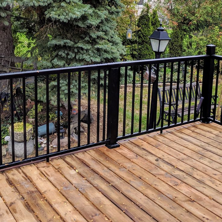 a wooden deck with black iron railings