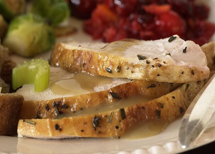 a white plate topped with meat and veggies next to cranberry sauce