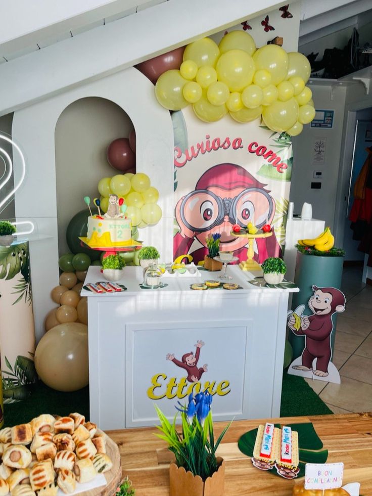 a table topped with lots of food and balloons