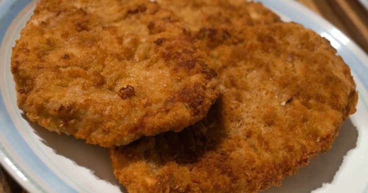 two fried meat patties on a white and blue plate