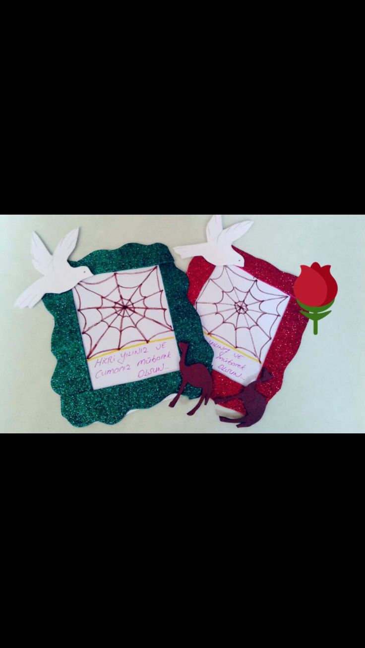 two pieces of paper with spider webs and roses on them, sitting next to each other