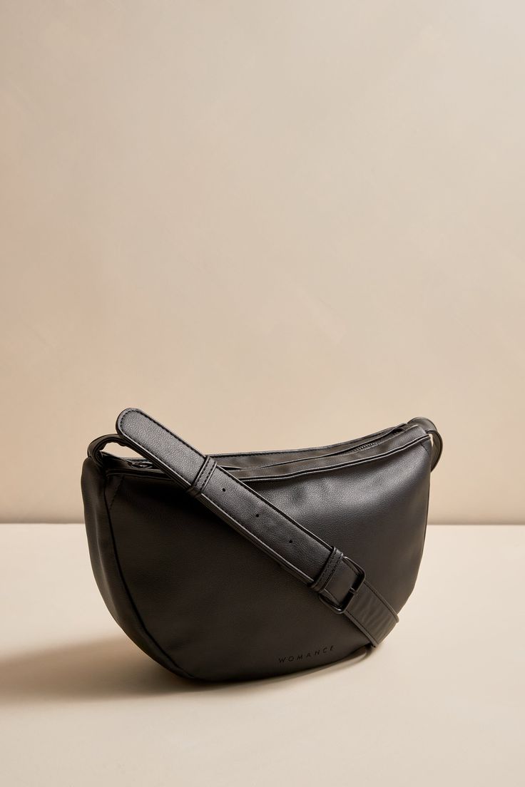 Introducing our brand new half-moon vegan leather handbag. This modern and stylish bag is the perfect accessory to any fall look. Our team loves it and we're sure you will too!Made from vegan leatherCruelty free and easy to care forTop zipper to keep your belongings safeWomance logo embossed on the frontStrap adjustable up to 39"Can be worn as a shoulder or cross-body bagTwo inside pockets (one with zipper)Dimensions: 12.5" (width) x 7.25" (height) x 3" (depth)Exterior: vegan leather, 100% PolyurethaneInterior lining: 100% polyester



Care Instructions: Hand wash with a clean damp cloth. Everyday Faux Leather Baguette Bag With Removable Pouch, Versatile Everyday Faux Leather Baguette Bag, Modern Faux Leather Baguette Bag With Zipper, Modern Faux Leather Baguette Bag, Trendy Soft Leather Crossbody Hobo Bag, Modern Faux Leather Hobo Bag, Versatile Faux Leather Baguette Bag With Removable Pouch, Modern Faux Leather Satchel Baguette Bag, Everyday Faux Leather Saddle Bag With Detachable Strap