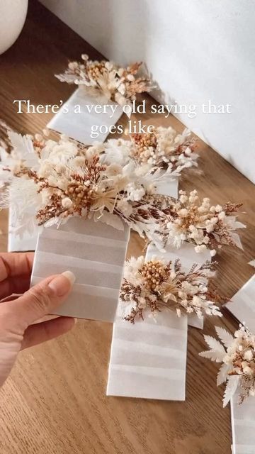 there is a person holding some flowers in front of a card that says, there's a very old saying that goes like