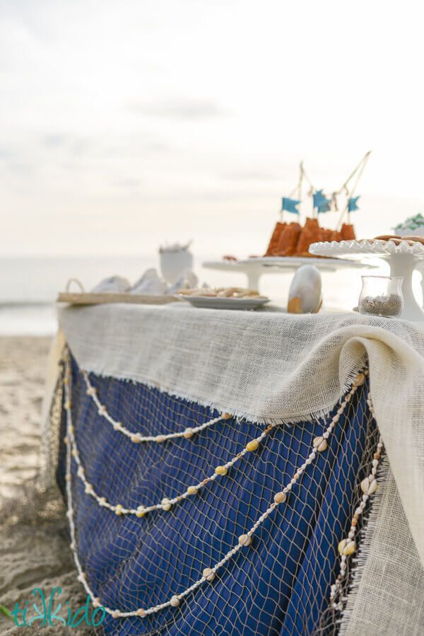 there is a blue and white table on the beach