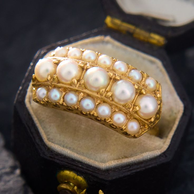 This majestic ring contains two rows of seed pearls encompasing a centered row of larger round pearls. The larger inner pearls and the smaller outer pearls are very well matched. The ring is crafted in buttery 18k yellow gold and is currently a size 6.5. Luxury Baroque Pearl Ring For Anniversary, Luxury Heirloom Pearl Ring, Luxury Timeless Open Pearl Ring, Vintage Pearl And **** Ring, Luxury Elegant Hallmarked Pearl Ring, Luxury Yellow Gold Pearl Ring With Brilliant Cut, Luxury Timeless Yellow Gold Pearl Ring, Pearl Design, Seed Pearl