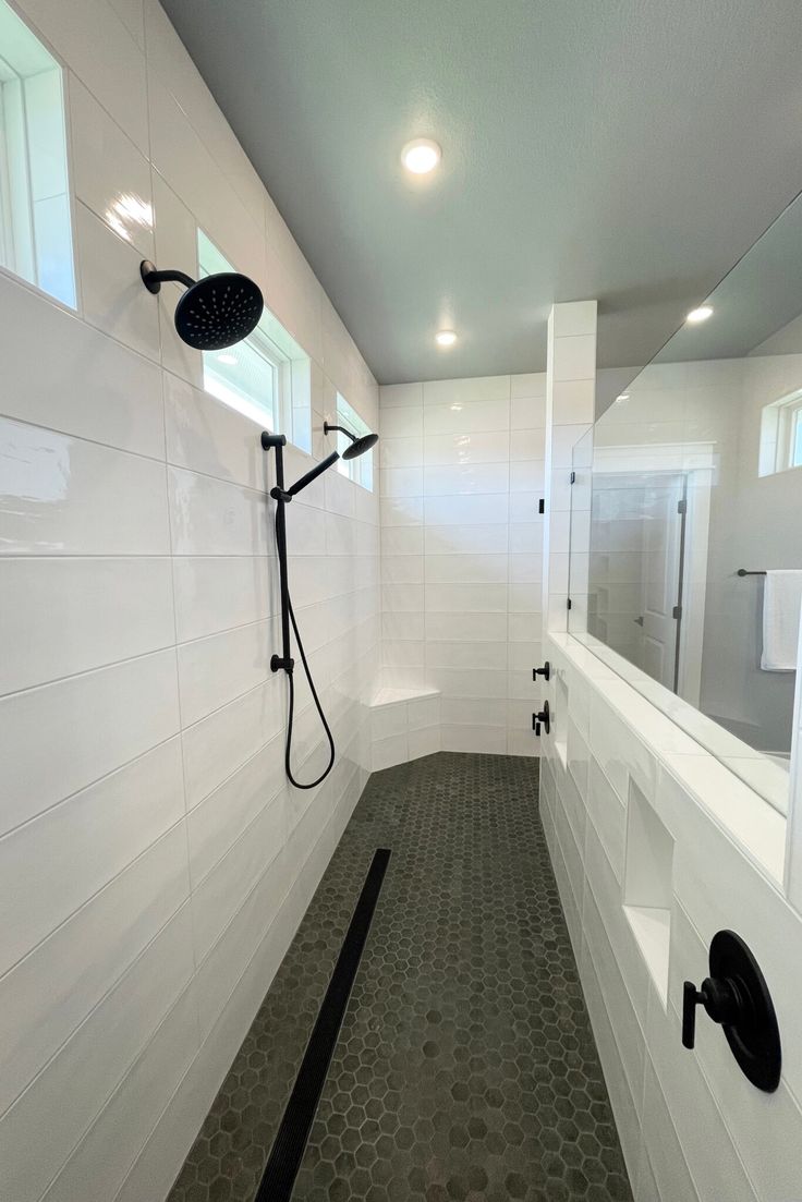 a bathroom with white walls and tile flooring next to a walk - in shower