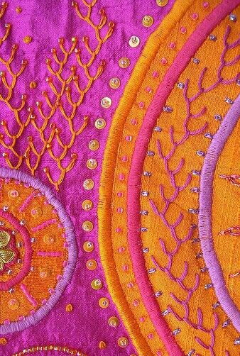 closeup of an orange and purple piece of cloth with designs on it's edges