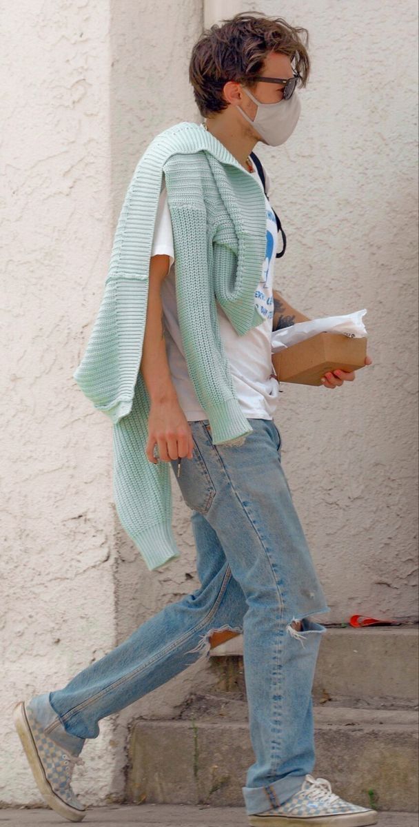 a man wearing a face mask walking down the street