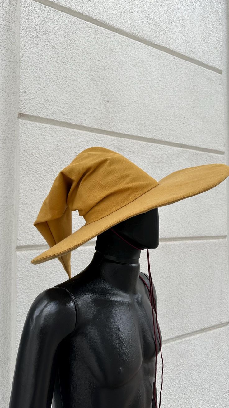 a black mannequin wearing a yellow hat on top of it's head