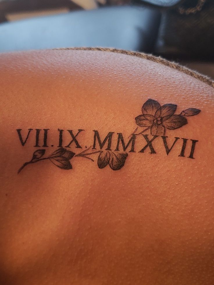 a close up of a tattoo on the back of a woman's shoulder that says vil xx mmxvi