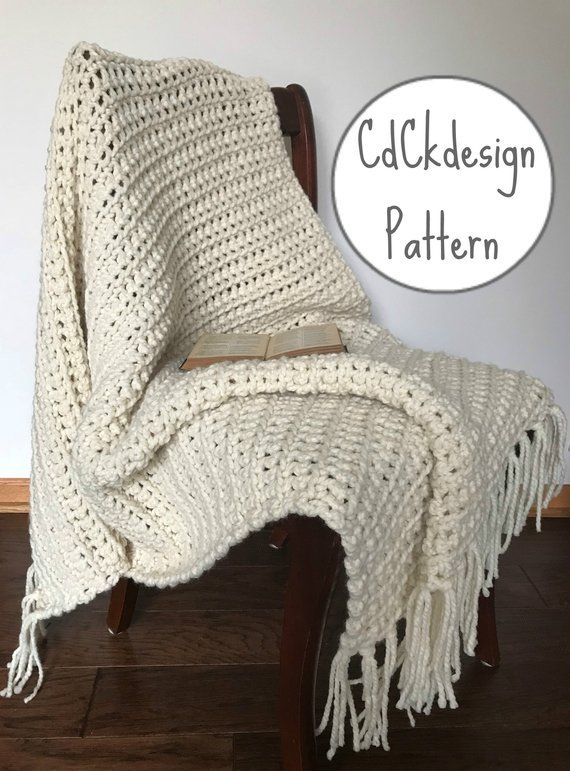 a white crocheted blanket sitting on top of a wooden chair