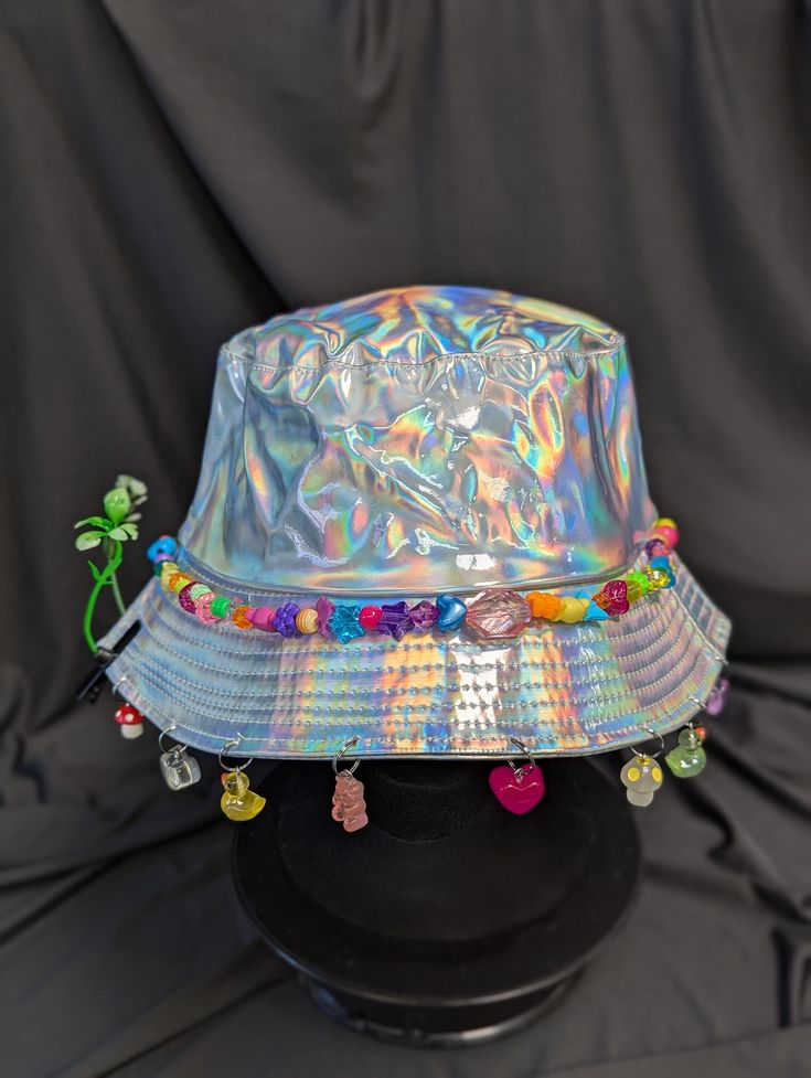 -hat color - silver -bead color - rainbow -charm color - rainbow -unisex adult size -inner circumference - 22.5in -crown dip - 3in -brim - 2.25in -NOT machine washable -Perfect for raves and outdoor festivals! Shipping within the US USPS First Class Package 3-9 days USPS Priority Mail 1-5 days USPS Priority Mail Express 1-3 days Shipping International  USPS First Class Mail International  -Varies- USPS Priority Mail International 6-14 days USPS Priority Mail Express International 3-9 days Shipping times are estimated, NOT GUARENTEED.  +International buyers are responsible for all import fees+ +Orders of $50+ may require signature confirmation upon delivery+ Trendy Silver Summer Hat, Adjustable High Crown Silver Hat, Adjustable Silver High Crown Hat, Fun Adjustable Hat For Carnival, Adjustable Rave Cap, Funky Multicolor Bucket Hat For Festivals, Whimsical Multicolor Adjustable Hat, Handmade Adjustable Silver Hats, Whimsical Adjustable Multicolor Hat