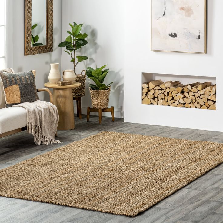 a living room with wood stacked on the floor and a rug in front of it