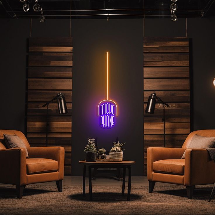 two chairs and a table in front of a wall with a neon sign on it