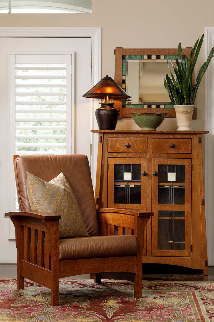 a wooden chair sitting in front of a cabinet and lamp on top of a rug