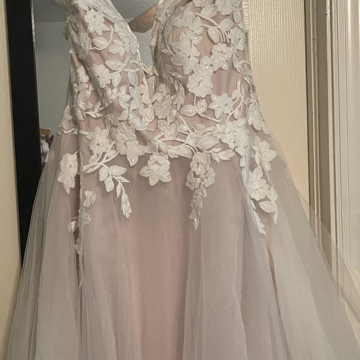 a dress hanging on a hanger in front of a door with a mirror behind it