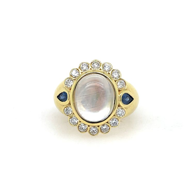 Mazza Moonstone, Sapphire, & Diamond Ring In 14K Yellow Gold. The Ring Features A Cabochon Moonstone, Two Pear Shape Blue Sapphires, & 0.70 Ctw Of Round Diamonds. Ring Size 7. Luxury White Multi-stone Gemstones, Timeless Round Cabochon Sapphire Ring, White Gold Cabochon Sapphire Ring, White Gold Sapphire Cabochon Ring, White Gold Sapphire Ring With Cabochon, Oval Diamond Moonstone Ring In Yellow Gold, Oval Moonstone Ring With Diamonds In Yellow Gold, Luxury Oval Moonstone Anniversary Ring, Heirloom White Moonstone Ring With Rose Cut Diamonds