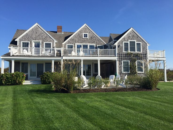 a large house sitting on top of a lush green field