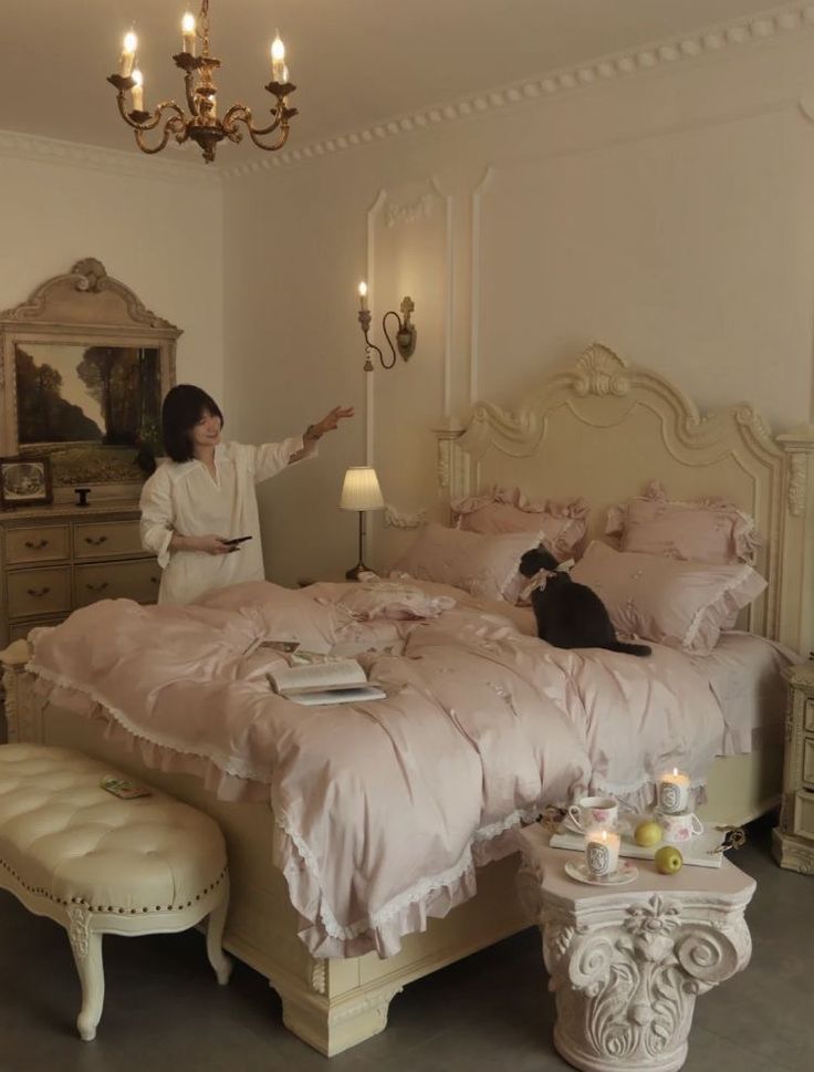 a woman standing in front of a bed with pink comforter and pillows on it