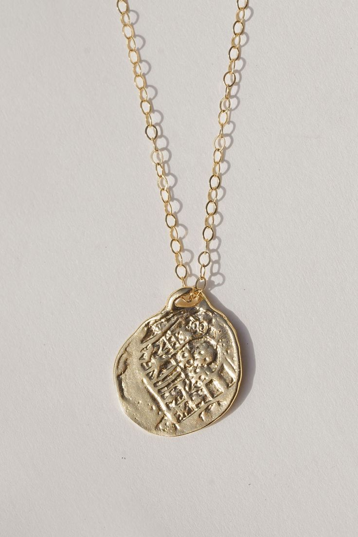 Reversible double sided Medallion charm necklace made from an old Spanish coin. A gorgeous and detailed gold necklace perfect for any occasion. Cast from an original ancient coin, the Medallion Necklace was designed to attract growth, fortune, and opportunity. Coins have a long history of bringing good luck and have become a symbol of prosperity and wealth. Throwing coins into a wishing well is a tradition that predates recorded history. A silver coin was used under the mast of a ship as it was 14k Gold Spiritual Coin Necklace With Round Pendant, Amulet Style Coin Pendant Jewelry In Recycled Gold, Amulet Style Jewelry With Coin Pendant In Recycled Gold, Recycled Gold Amulet Jewelry With Coin Pendant, Recycled Gold Coin Pendant Amulet Jewelry, Recycled Gold Medallion Coin Pendant, Gold Medallion Necklace For Good Luck, Spiritual 14k Gold Charm Necklaces With Coin Pendant, 14k Gold Amulet Coin Necklace Tarnish Resistant