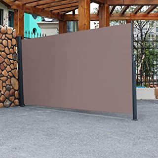 a large screen in front of a pile of firewood on the ground next to a building