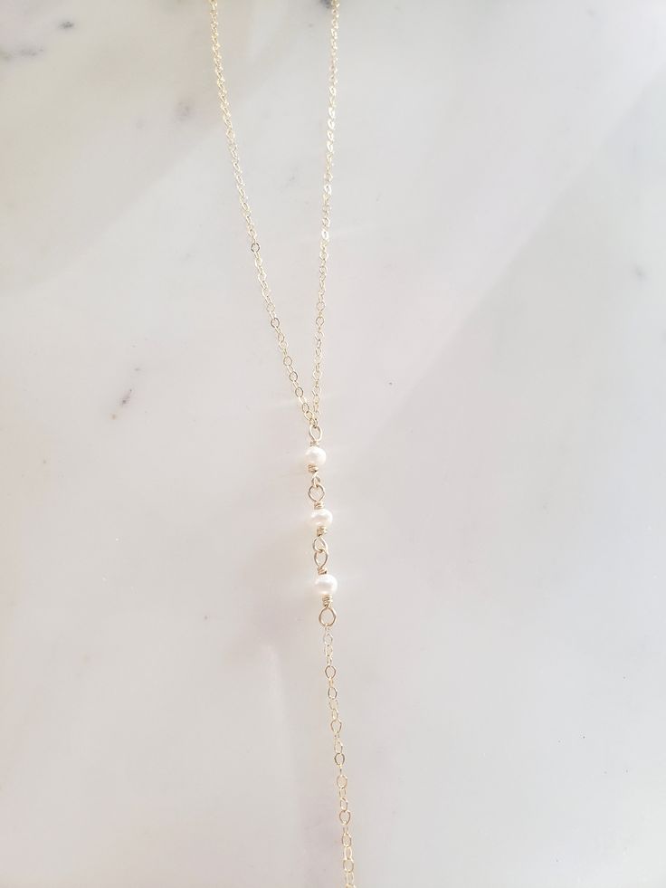 "These dainty and thoughtfully designed necklaces are stunning paired as a set or on their own! Would be wonderful for a bride or as a feminine and lovely touch to your every day. Genuine freshwater pearls are wire wrapped in a minimal/vintage-y/boho style. Made from top quality materials- true 14k gold fill or solid sterling silver, will not tarnish or turn you green, wear 24/7! Secured with an easy to use oval lobster clasp. Lead and nickel free. Excellent for sensitive skin! Come packaged in Dainty Long Backdrop Necklace With Clavicle Chain, Elegant Long Necklaces For Weddings, Elegant Adjustable Dangle Layered Necklace, Pearl Chain Necklace With Pearl Charm For Wedding, Pearl Drop Lariat Necklace For Wedding, Long Pearl Drop Lariat Necklace For Wedding, Feminine Gold Necklace With Pearl Drop, Dainty 14k Gold-filled Pearl Chain Jewelry, Wedding Pearl Drop Lariat Necklace