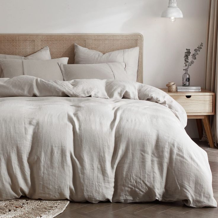 an unmade bed with white linens and pillows