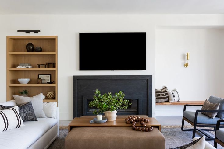 a living room filled with furniture and a flat screen tv mounted on the wall above a fireplace