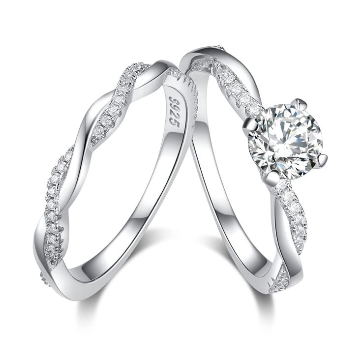 two white gold wedding rings with diamonds on each side and an engagement ring in the middle