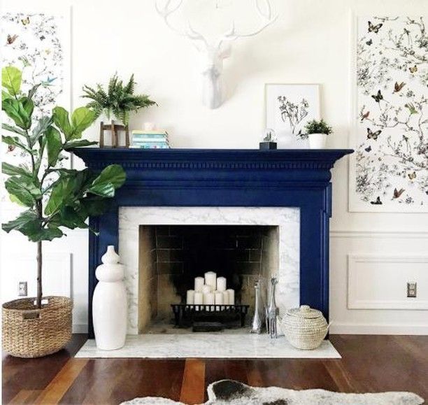 a living room with a fire place and various decorations on the fireplace mantels