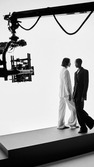 two people standing on a platform in front of a camera