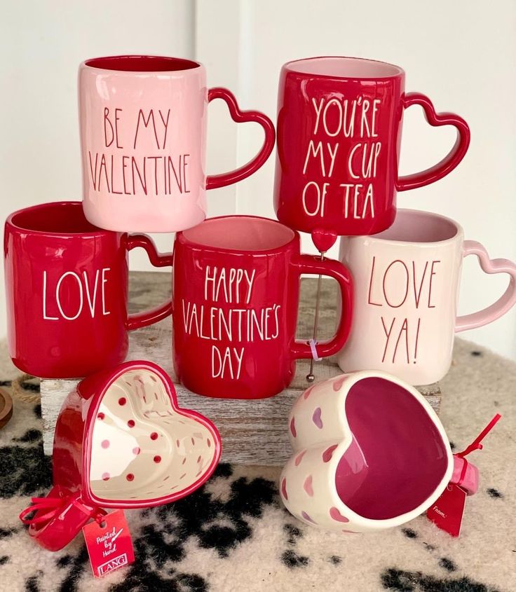 valentine's day coffee mugs are stacked on top of each other with hearts