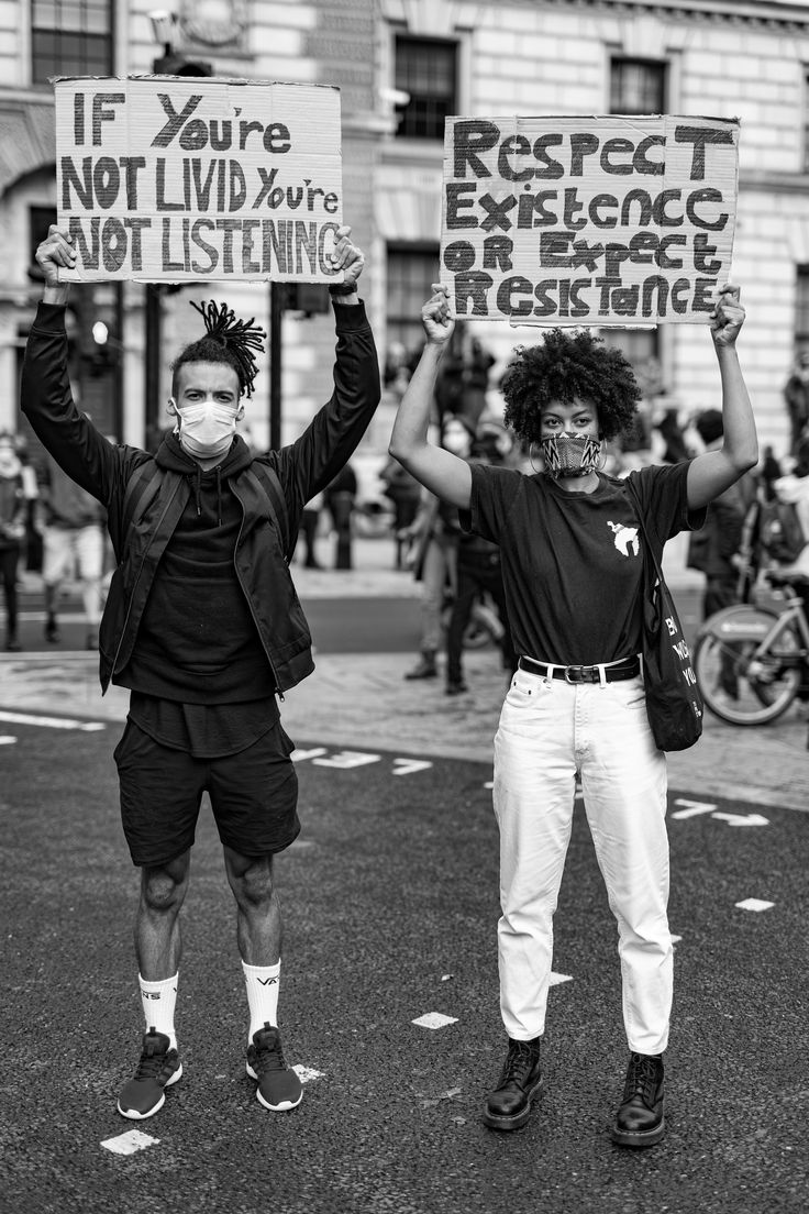 two people holding up signs in the street