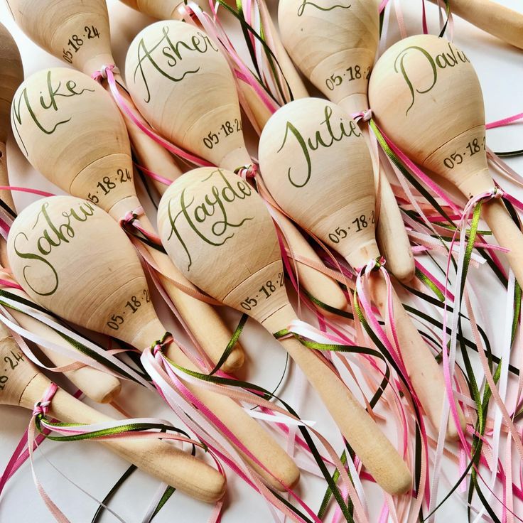 many wooden spoons with names on them are lined up in a row and tied together