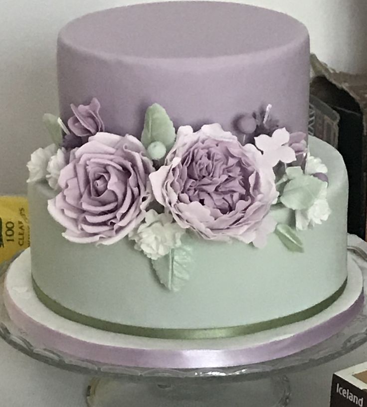 a three tiered cake with purple flowers on it