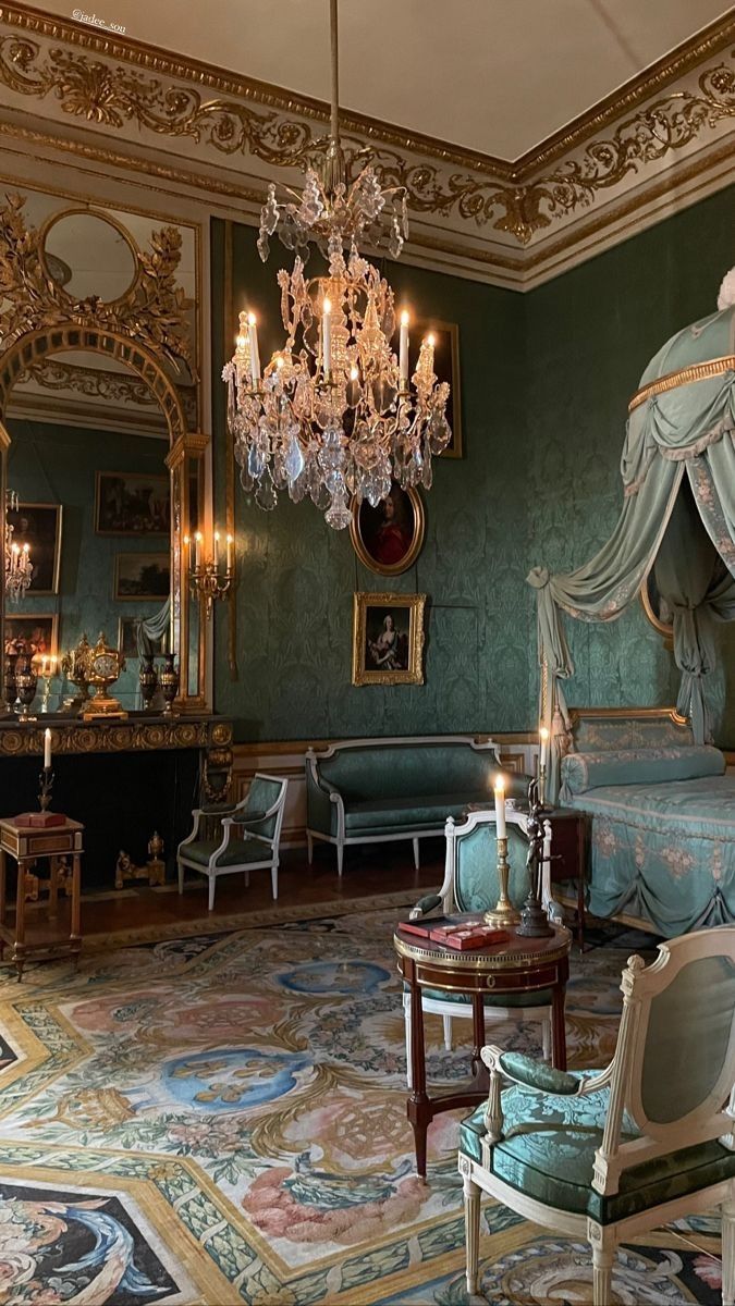 an ornate bedroom with chandelier, bed and chairs