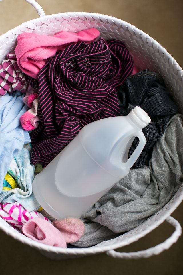 a white bucket filled with clothes and a plastic bottle