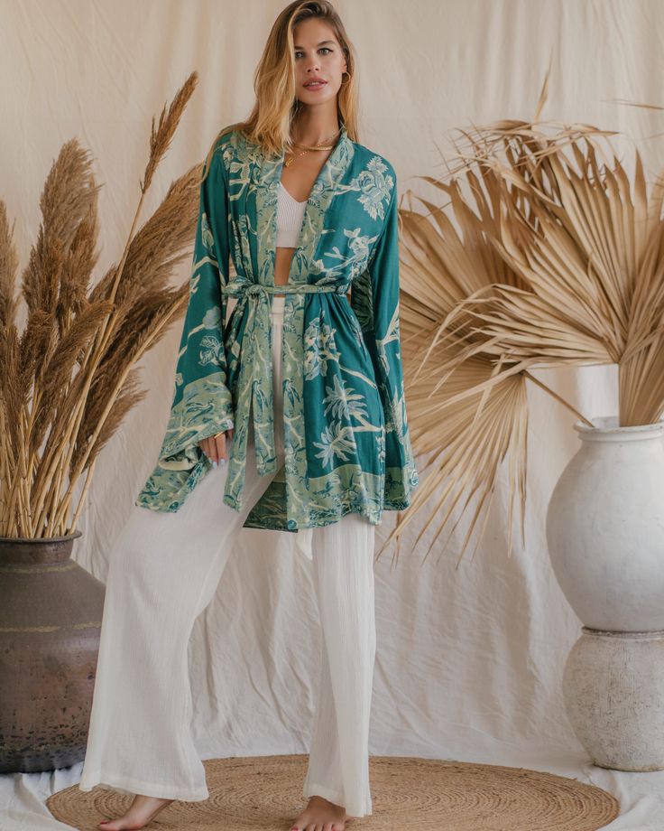 Our Short Kimono offers an easy, relaxed fit, combining comfort with understated elegance. Its fluid silhouette adds a touch of effortless charm to any outfit, making it a versatile piece for both casual days and special moments. Feminine Summer Kimono For Loungewear, Elegant Long Sleeve Sleepwear For Vacation, Feminine Summer Loungewear Kimono, Elegant Long Sleeve Relaxed Fit Kimono, Relaxed Fit V-neck Kimono For Loungewear, Chic Flowy Kimono For Loungewear, Chic Spring Loungewear Kimono, Spring Loungewear Kimono, Elegant Relaxed Fit Sleepwear For Spring